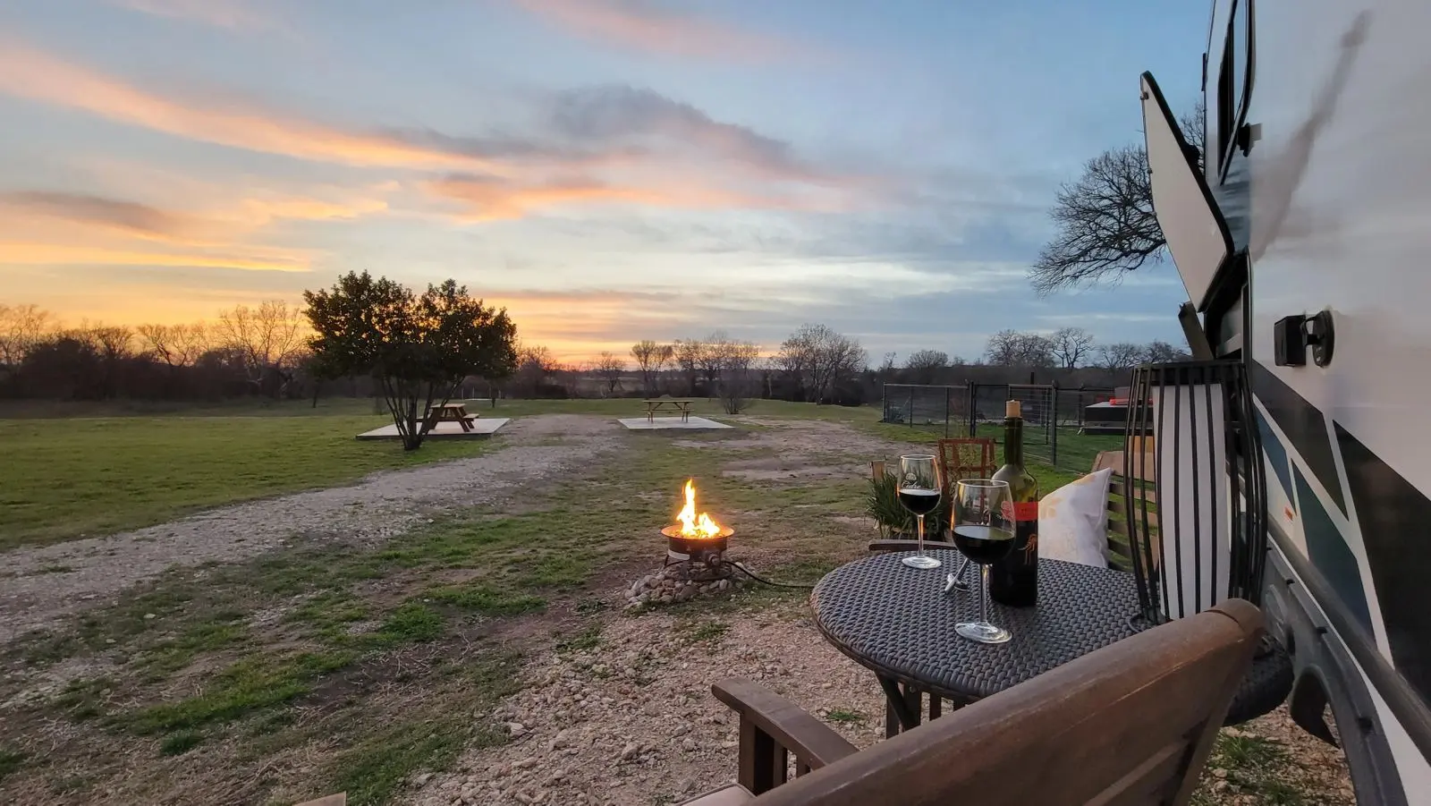 Patio view of River RV at sunset with the fire pit lit