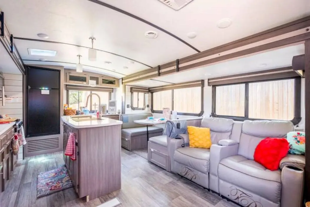 Living room, dining table, and kitchen inside River RV